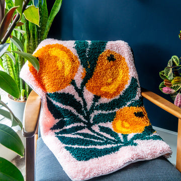 A bounty of oranges rug against dark blue background