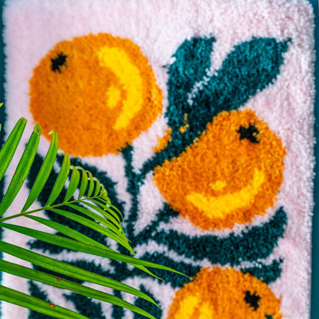 Flatlay of bounty of oranges latch hook rug