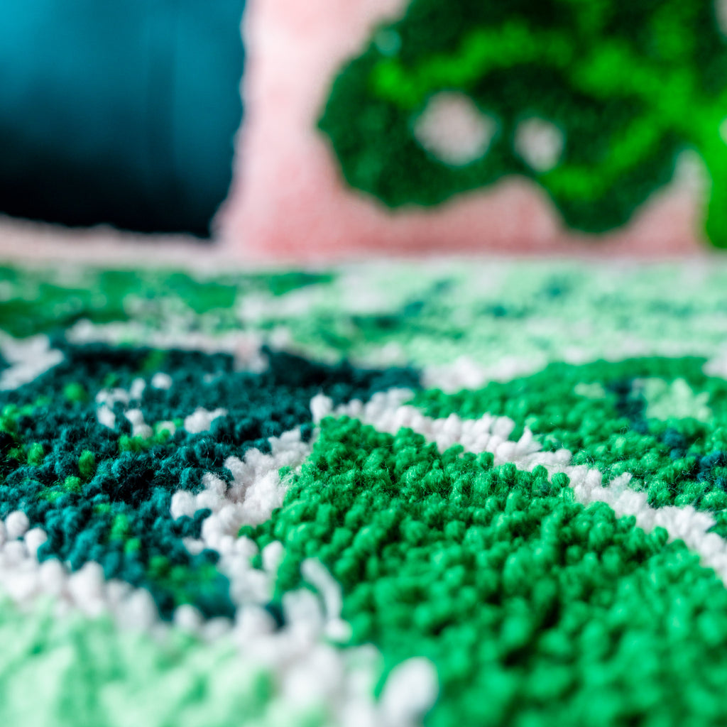 Close up of unbeleafable rug with lush and leafy cushion 