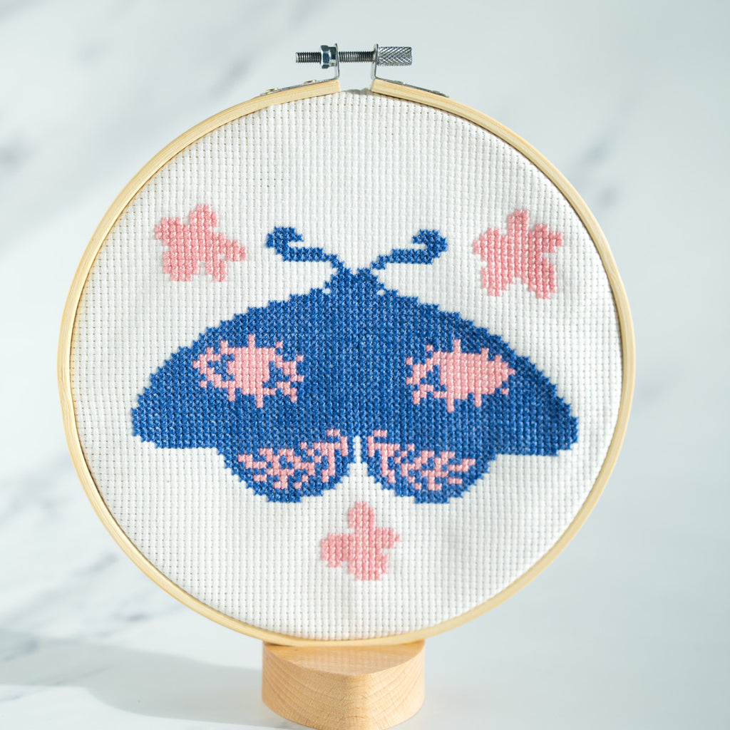 Moth with eyes surrounded by flowers on finished cross stitch kit