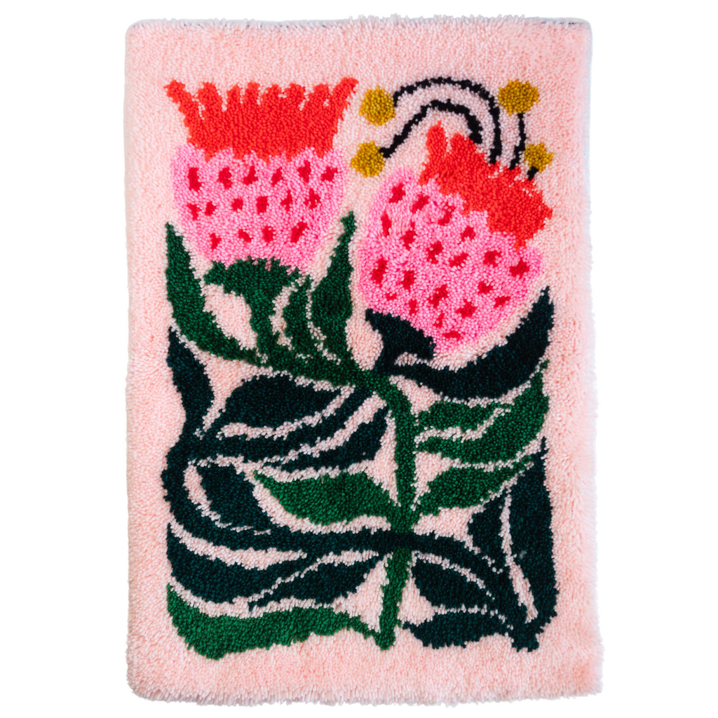 Cutout of sugarbush rug with dark green leaves and pink flowers  on white background 