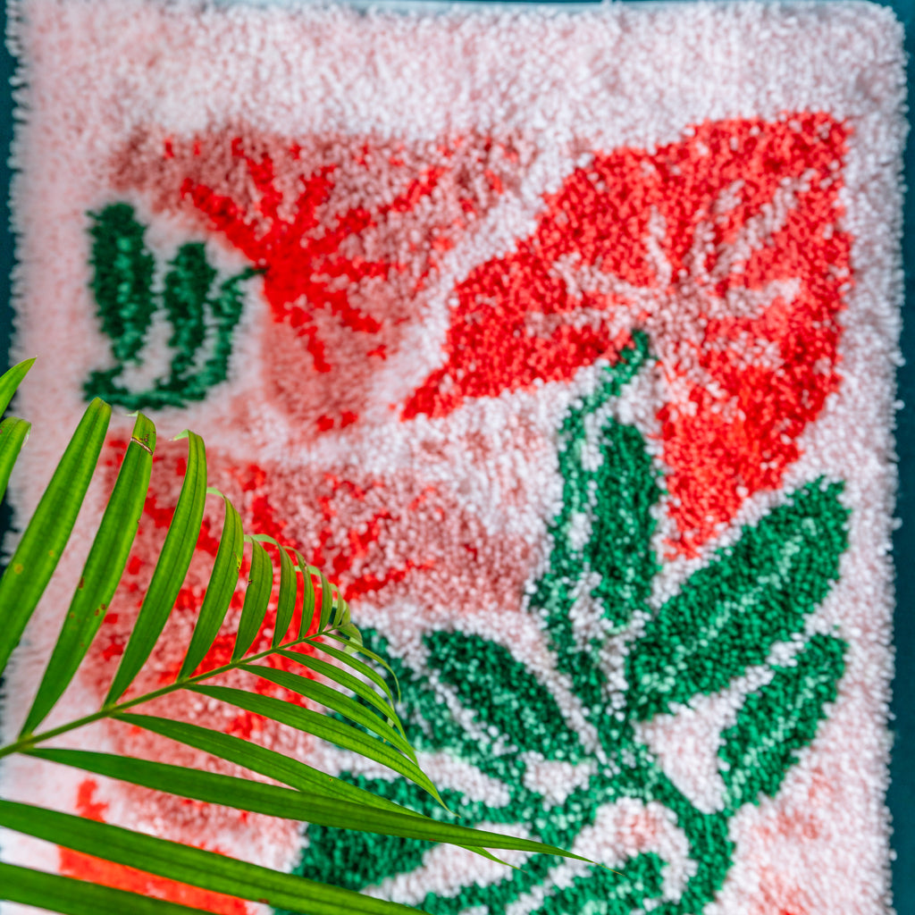 Top down view of flowers on latch hook rug with plant 